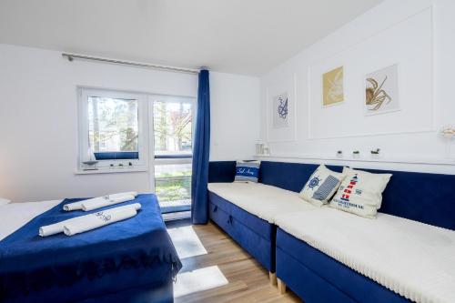 Habitación con 2 camas azules y ventana. en Apartament 8B Blue Marine Poddąbie en Poddąbie