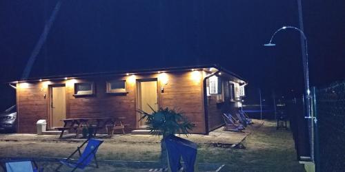 a small cabin with a table and chairs at night at Apartamenty przy Jeziorze Żywieckim z widokiem na Skrzyczne in Żywiec