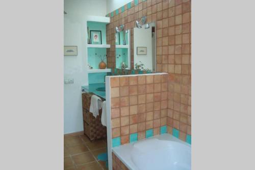 a bathroom with a tub and a sink and a mirror at Sa Vinyeta in Sant Llorenç de Balafia