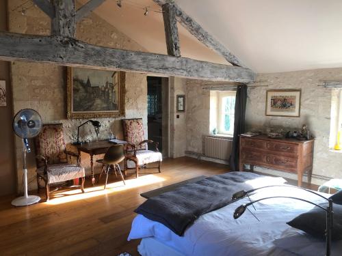 a bedroom with a bed and a desk in it at Las Canéres in Castelnau-dʼArbieu