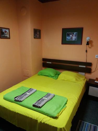 a bedroom with a green bed with two towels on it at Стаи за гости ОРЕХА Троян Private rooms Oreha in Troyan