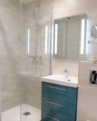 une salle de bain avec un lavabo et une douche en verre dans l'établissement Chambres d'Hôtes Le Petit Nailly, à Magny-les-Hameaux