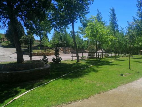 a park with trees and grass and a path at HOTEL MASIA EL MOLINETE in Mora de Rubielos