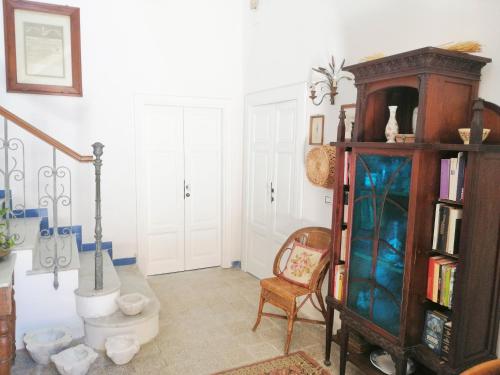a living room with a book shelf and a chair at Panoramic Apartments in Villa in Center "The Beach and The Cliff" 1 in Agropoli