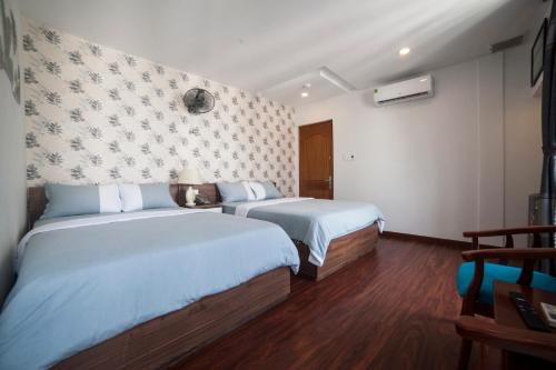 a hotel room with two beds and a wall at Tre Việt Tuy Hòa Hotel in Tuy Hoa