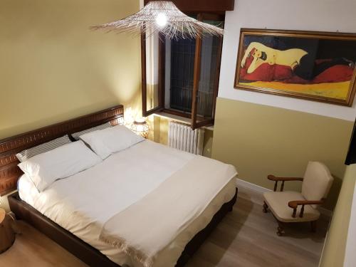 um quarto com uma cama, uma cadeira e uma janela em RESIDENZE AI SALVI em Verona