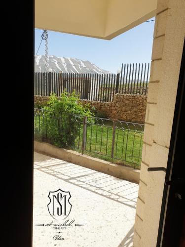 a view of a fence from a door at Saint Michel Chalets in Al Arz