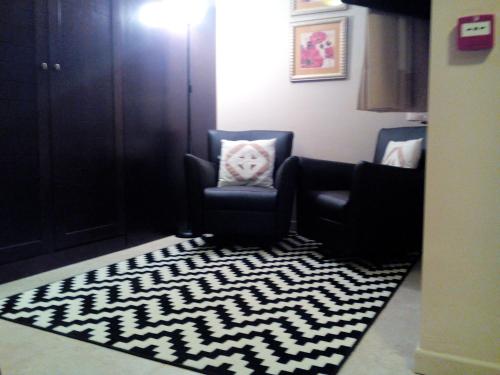 a living room with two chairs and a rug at HOTEL MASIA EL MOLINETE in Mora de Rubielos