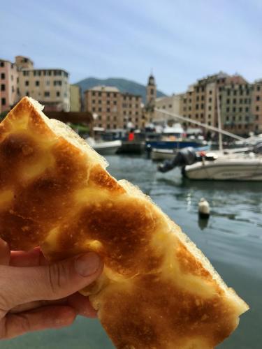 a person holding a piece of bread near a harbor at SilMar in Camogli