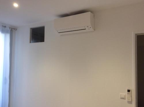 a ceiling fan in a room with a white wall at Au cœur de la cité médiévale avec petite vue mer in Bonifacio