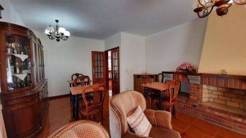 a living room with wooden chairs and a fireplace at Casa de Vilarinho in Arouca