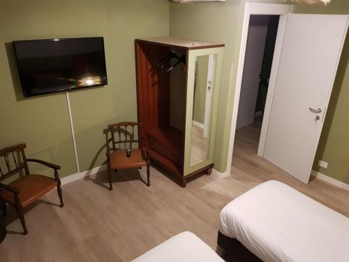 um quarto com uma cama, um espelho e uma televisão em RESIDENZE AI SALVI em Verona