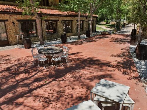 a patio with a table and chairs in a yard at HOTEL MASIA EL MOLINETE in Mora de Rubielos