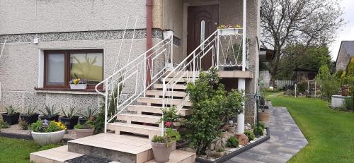 a house with a staircase in front of a window at Lawendowy Dom in Besko