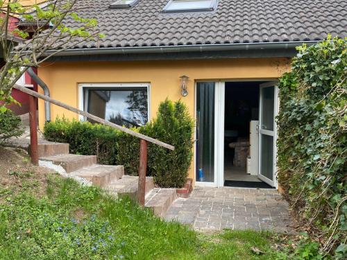een geel huis met een trap naar een deur bij Appartement Eifelsteig in Hollerath