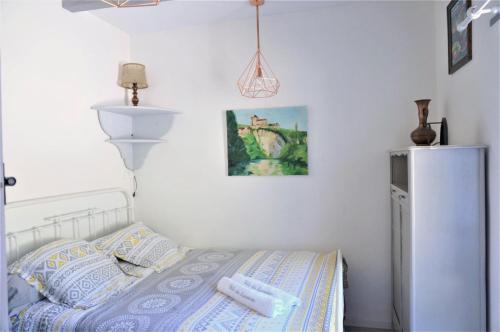 Dormitorio pequeño con cama y nevera en gite du tourneur, en Saint-Cirq-Lapopie