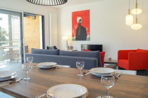 een woonkamer met een tafel met borden en wijnglazen bij Le Saint-Jore - 2 bedroom apartment balcony & parking in Saint-Jorioz