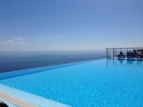 a large swimming pool with a view of the ocean at Viangella - Dramatic sea view! Top floor 2km to Monaco in Cap d'Ail