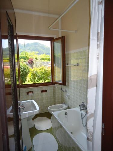 a bathroom with a tub and a toilet and a sink at Villa Soghetta Typ S3 in Crone