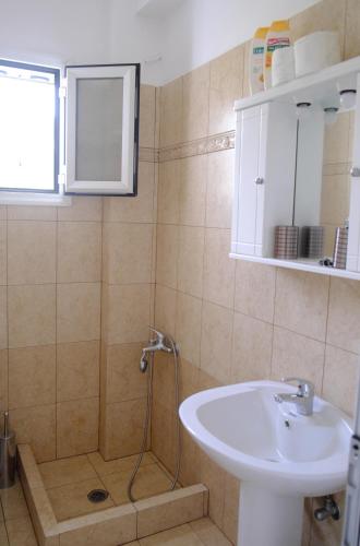 a bathroom with a sink and a shower at Marathona's Apartment in Egina