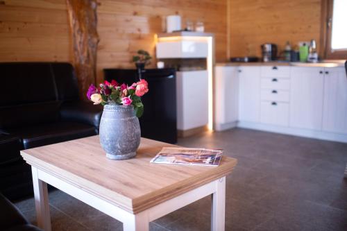 a vase with flowers sitting on a coffee table at Brvnara Aurora Vista in Velika Remeta