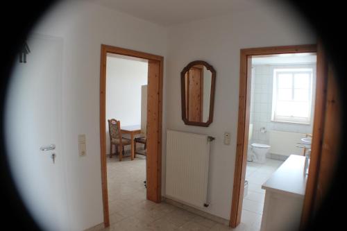 een badkamer met een toilet en een spiegel aan de muur bij Ferienhof Frerichs ihr Feriendomizil am Meer in Wangerland