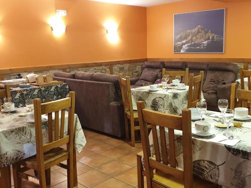 un restaurante con mesas y sillas y un sofá en Zubeltzu Torre, en Zumaia