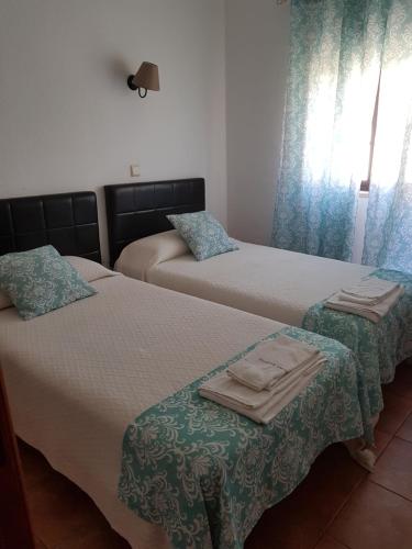a bedroom with two beds with towels on them at Quartos Abelha in Porto Covo