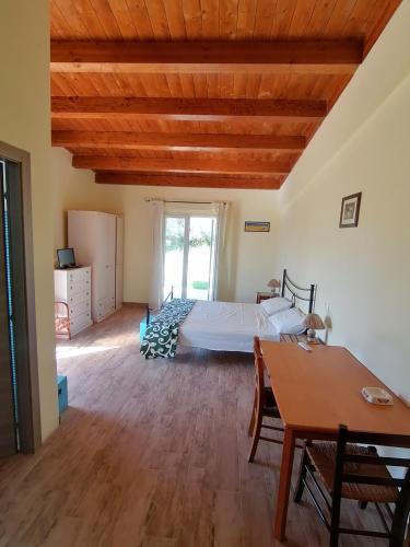 um quarto com uma cama e um tecto de madeira em agriturismo oca giuliva em Lido dei Pini