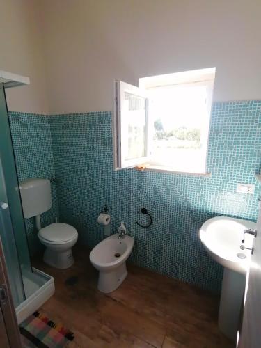 a bathroom with a toilet and a sink and a window at agriturismo oca giuliva in Lido dei Pini