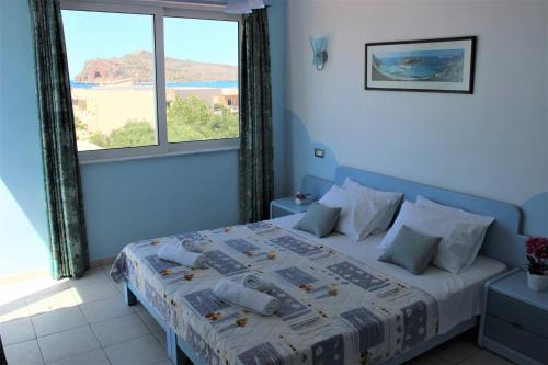 a bedroom with a bed with a large window at Mastorakis Village in Agia Marina Nea Kydonias