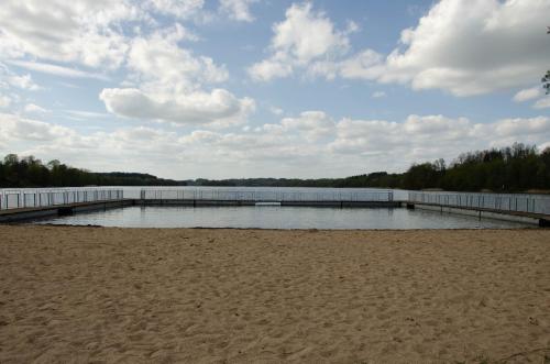a dock on a beach next to a body of water at Domek Rospuda in Rospuda
