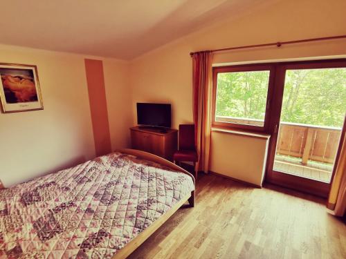 a bedroom with a bed and a window at Ferienwohnung Grabner in Fieberbrunn