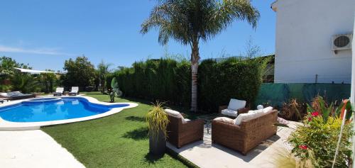 un patio trasero con una palmera y una piscina en 142B Dehesa Baja, en Alhaurín el Grande