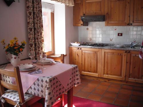 cocina con mesa y mantel rosa en Residence Pavou, en Cogne