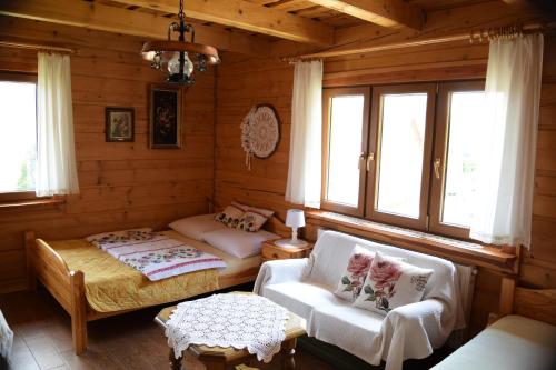 ウストシキ・ドルネにあるPrzystań Gromadzyńのベッド、ソファ、テーブルが備わる客室です。