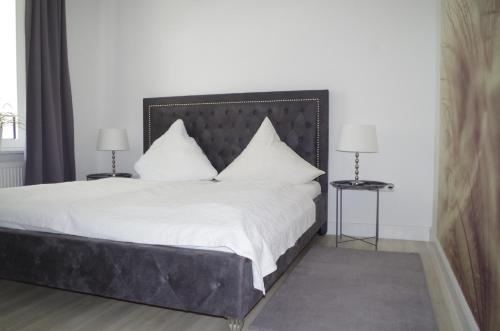 1 dormitorio con 1 cama grande con sábanas y almohadas blancas en Relaxzone 202 - Hohen Wieschendorf en Hohen Wieschendorf
