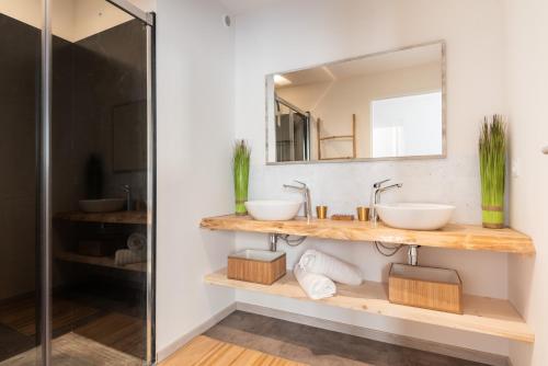 a bathroom with two sinks and a mirror at Le Jardin de La Tour Pinte in Carcassonne