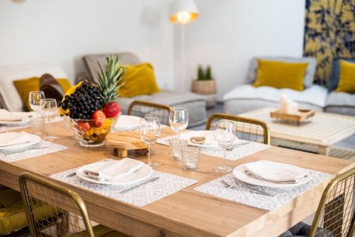 - une table à manger avec un bol de fruits et des verres à vin dans l'établissement Le Jardin de La Tour Pinte, à Carcassonne