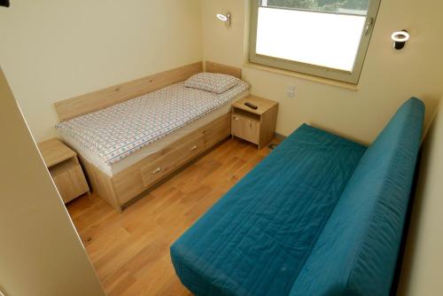 a small bedroom with a bed and a window at Dom Żeglarza in Puck