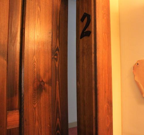 a wooden door with the number two on the wall at El Rincón de Rascafría in Rascafría
