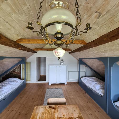 a large room with two beds and a chandelier at Lysefjorden - Gøysa Gard in Forsand