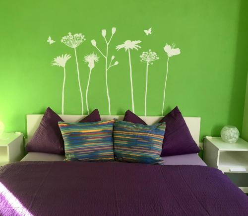 a bedroom with a bed with purple sheets and dandelions at Ca' di Pincia in Astano