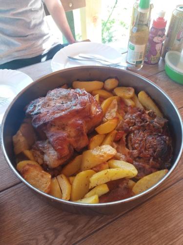 a pan of food with meat and potatoes on a table at Weekend House Petar in Lusnić