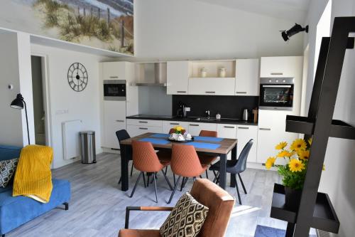 een keuken en eetkamer met een tafel en stoelen bij Appartement zeldenrust in Oostkapelle