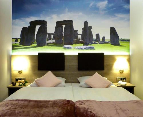 a bedroom with a bed with a picture of stonehenge at Hotel Wurms in Düsseldorf