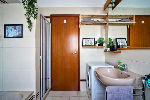 a bathroom with a sink and a toilet and a door at Casa Zoe Apartment Free parking,self check in & free wi fi in Parma