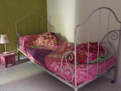 a bedroom with a metal bed with pink sheets at La Maison du Bien Etre in Aigues-Mortes