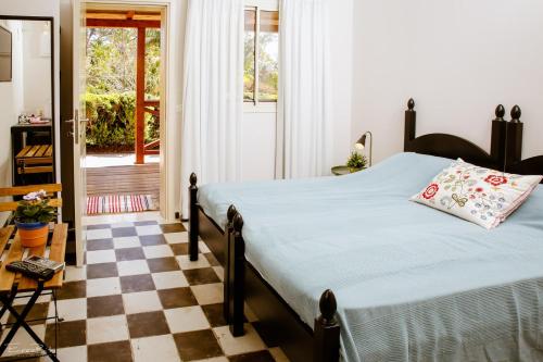 1 dormitorio con 1 cama y suelo a cuadros en Shaar Hagolan Kibbutz Country Lodging, en Shaar Hagolan