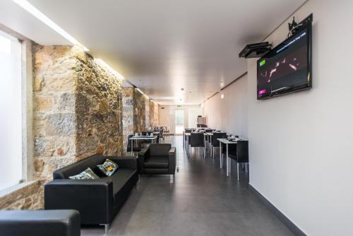 a dining room with tables and chairs and a tv at V Dinastia in Lisbon